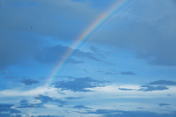 Fototapeta na wymiar Rainbow in the blue sky with clouds