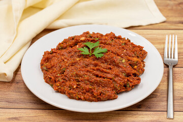 Chili paste on a wooden background. spicy paste. A kind of adjika. Turkish cuisine appetizers. Horizontal view. Close up