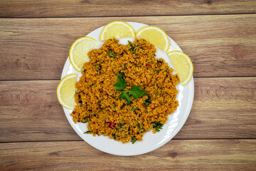 Bulgur salad (kisir) on a wooden background. Traditional delicious food. Turkish cuisine appetizers. Top view. close up