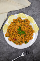 Bulgur salad (kisir) on a dark background. Traditional delicious food. Turkish cuisine appetizers. Top view. close up