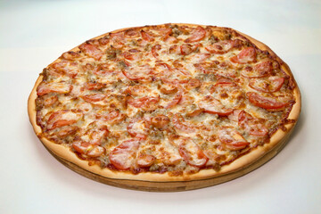 Fresh baked pizza with cheese and pieces of sausage and tomatoes