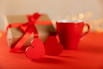 Gift box, red heart and red cup of tea on a red background. Valentine's Day gift. Holidays and love concept.