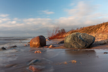 Baltic Sea rocks and beach sand at sunset