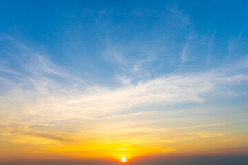 Obraz premium Dramatic sky of golden or yellow sunset light with blue sky and white clouds at evening time.