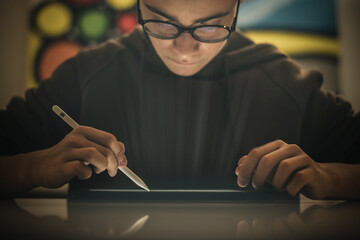 Teenager drawing with tablet and virtual pen. Millennial student doing homework with new technology...