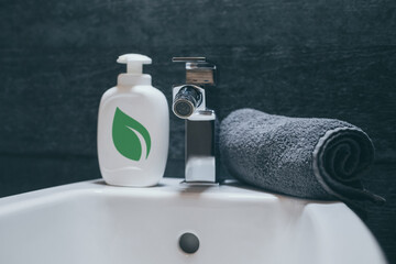 Closeup view of a bidet with rolled up towel, soap dispenser. Modern environment bathroom fixtures...