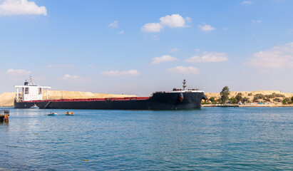 Bulk carrier ship with black hull passes the Suez Canal