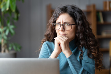 Frustrated worried business woman sit at laptop stressed think about bad news, problem at work, trouble solution. Trainee nervous about mistake or deadline. Afraid freelance worker waiting for email