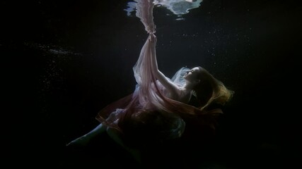 dreaming woman floating in dark depth of sea or ocean, magical dream, underwater