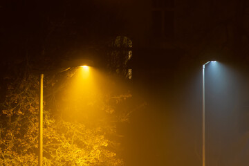 Orange and white streetlights on a foggy night