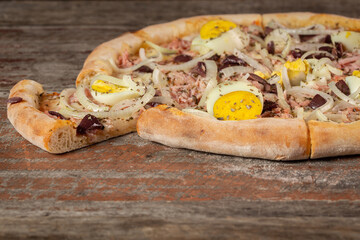 slice of Portuguese Pizza. Portuguese Pizza is a Brazilian pizza made from onion, pepperoni, egg, olive.