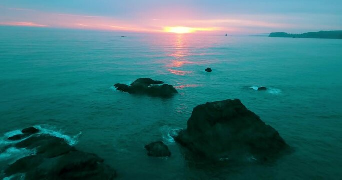 Aerial Descending Beautiful Shot Of Rocks In Sea Against Sky During Sunset - Ruby Beach, Washington