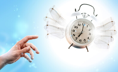 Hand catching a flying alarming clock. Time control management concept.