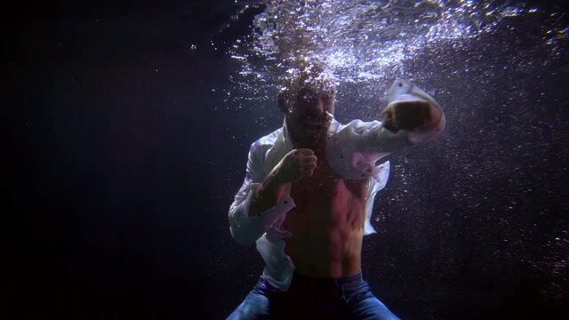 boxer is punching and floundering in water of swimming pool, underwater shot