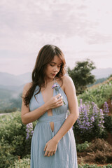 Fototapeta na wymiar Portrait of thai young woman enjoying in blooming flower field