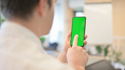 Young Man Using Smartphone with Green Chroma Screen