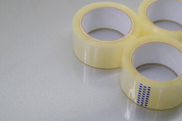Three rollers of transparent tape. Stationery and packaging consumables. Selective focus.