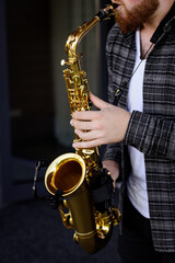 Obraz premium Hands of young musician man plays on saxophone
