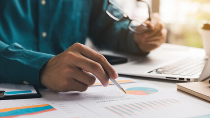 Close up view of businessman executive analyzing and planning business performance from financial data, analyzing finance data and economic growth graph chart.
