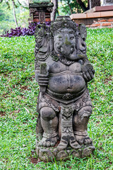 Fototapeta premium Traditional Ganesha statue with intricate stone carvings. Stone Ganesha sculpture perfect for spiritual decoration. Elegant Ganesha statue with detailed artistic features