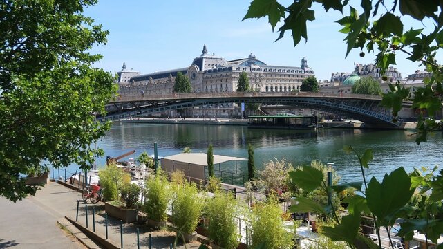 Paysage urbain dans la ville de Paris, vue sur le musée d’Orsay et le pont passerelle Léopold Sédar-Senghor sur la Seine, avec des arbres (France)