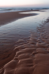 Baltic Sea rocks and beach sand at sunset