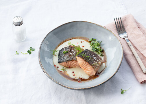 Salmon with mashed potatoes with seasonings on ceramic plate