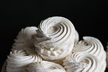 Obraz na płótnie Canvas Fragrant white marshmallow with cinnamon close-up on a dark background