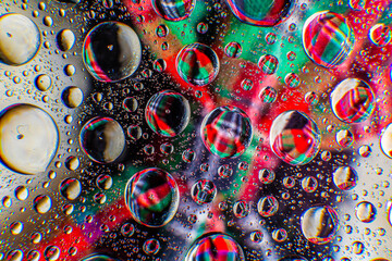 Water droplets on a glass in form of lenses with a colourful background. Wallpaper for screen. Abstract background.