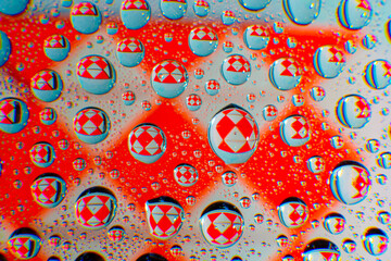 Water droplets on a glass in form of lenses with a colourful background. Wallpaper for screen. Abstract background.