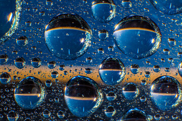Water droplets on a glass in form of lenses with a colourful background. Wallpaper for screen. Abstract background.