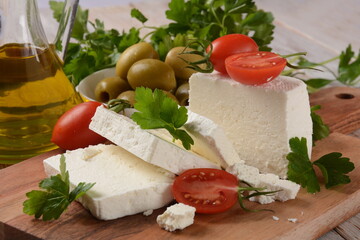 Feta cheese, olives and cherry tomatoes, green herbs and olive oil. Greek snack