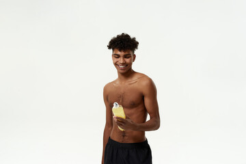 Fototapeta premium Black sportsman looking on bottle with sport drink