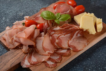 Italian cured pork shoulder. Antipasto Platter coppa stagionata and cherry tomatoes.  Traditional sliced sausage with spices