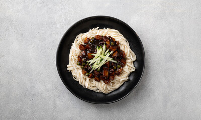 Jajangmyeon, Korean noodles in black bean sauce on a light concrete background, top view