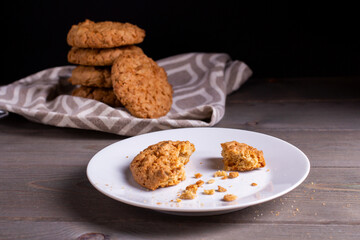 Freshly baked warm oatmeal cookies on a cooling rack on a dark background