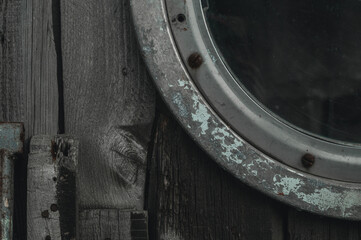 Part of the porthole on the wooden wheelhouse of an old ship. Selective focus