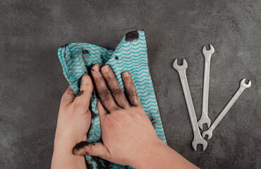 Cleaning dirty hands with a piece of clothes, fuel oil, mechanic worker, repair service, dark...