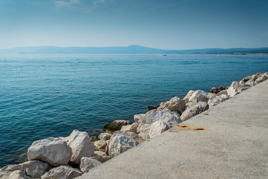 The quay of Crikvenica with stones under blue sky. Crikvenica is a popular holiday resort in Kvarner riviera in Croatia