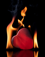 Red heart burnt on black background