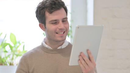 Portrait of Man Celebrating on Tablet in Office