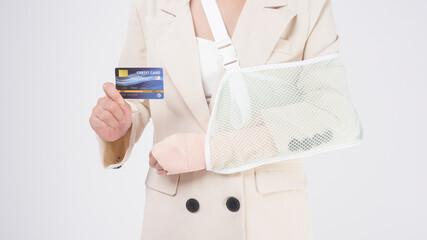 Portrait of young woman with an injured arm in a sling over white background in studio..