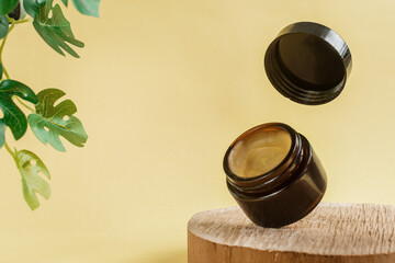 Glass cosmetic bottle or essential oil with Vitamin and prebiotic serums. Cosmetics in a jar for the care of hair and skin of the face, body on a beige