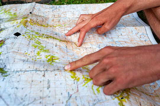 Hands palms showing trekking path on map with fingers measuring. Karakol valley, Issyk-kul region, Ala-kul lake Terskey Alatau mountain range, Kyrgyzstan, Central Asia.