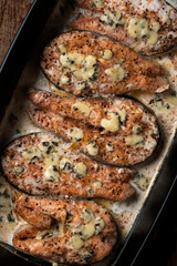 Salmon steak with creamy blue cheese sauce in a ceramic form. Restaurant food. Seafood. Rustic style. Flat Lay.