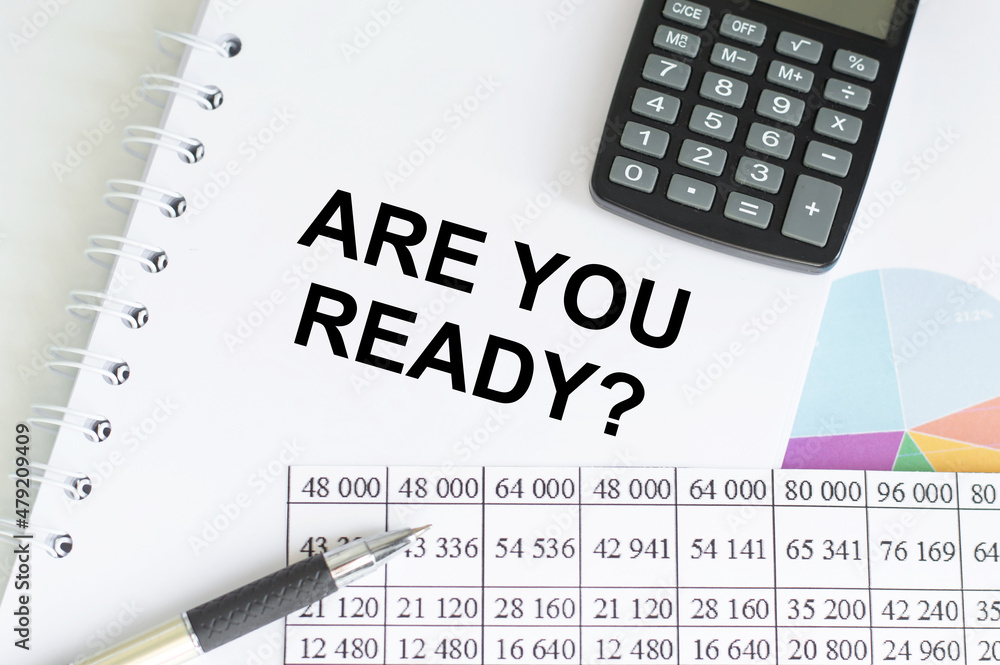 Poster are you ready text on notebook on the table next to the calculator, pen, graphs with reports