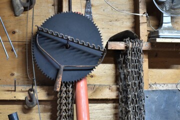 Interior of garage with various tools hanging on wall in disorganized way.