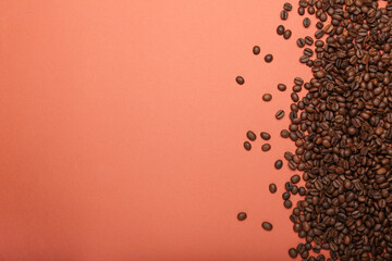 scattered coffee beans in the corner of the screen on a pink background  top view space for text