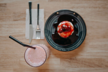 Attractive Young Man Eating Breakfast, Drinking Coffee and Having a Slice of Cake