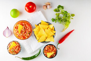 Salsa sauce and ingredients. Mexican homemade salsa sauce and nacho chips on a white background. Food background. Top view